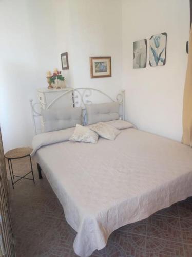 a bedroom with a white bed with a white bedspread at Mono Lu Lioni in Lu Lioni