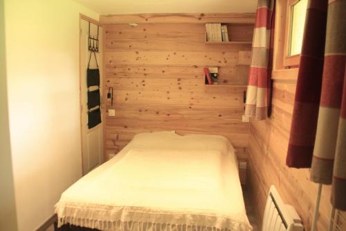 - une petite chambre avec un lit dans un mur en bois dans l'établissement Ours Blanc ORB NATURE & QUIET 4 Pers, à Châtel