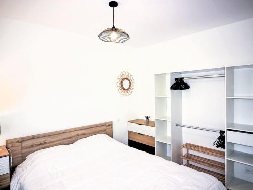 une chambre blanche avec un lit et un bureau dans l'établissement Apartment Cap Océan-7 by Interhome, à Capbreton