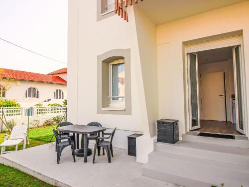 une terrasse avec une table et des chaises à côté d'une maison dans l'établissement Apartment Cap Océan-7 by Interhome, à Capbreton