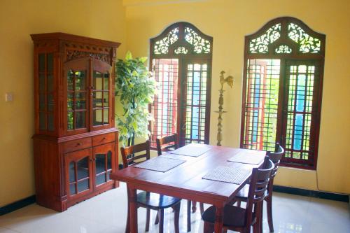 ein Esszimmer mit Tisch und Stühlen und Fenstern in der Unterkunft Tiny Royal Palace in Unawatuna