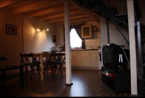 a kitchen and dining room with a table and chairs at Domek KLIMATYZOWANY piętrowy - Domki u Staszka in Rusinowo