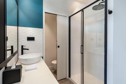 a bathroom with a white sink and a shower at Aloft Hotel, By Marriott in Dijon