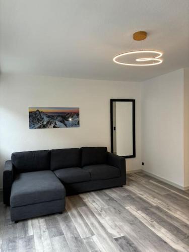 - un salon avec un canapé noir et un plafond dans l'établissement Le Nocturno, à Cluses