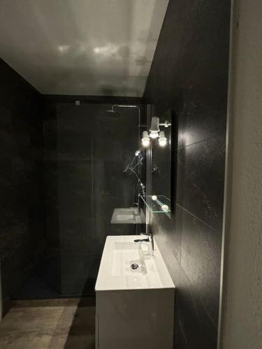 une salle de bain avec un lavabo et un miroir dans l'établissement Le Nocturno, à Cluses