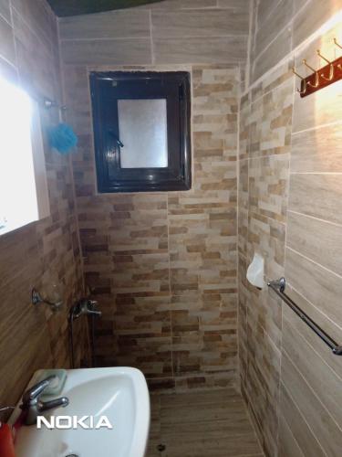 une salle de bain avec un lavabo et une télévision au mur dans l'établissement mountain and sea in kallithea Halkidiki, à Kallithéa Halkidikis