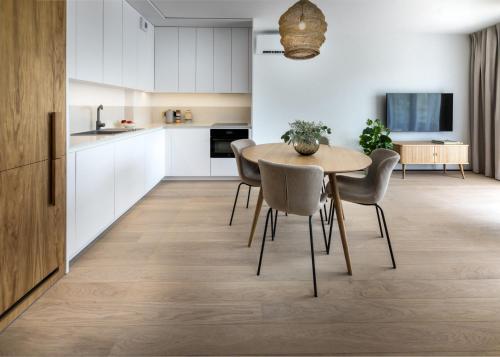 a kitchen and dining room with a table and chairs at Apartamenty na Półwyspie Wydma&Las in Jastarnia