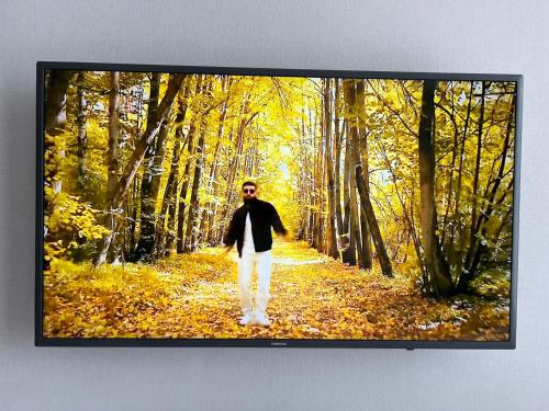 a man walking down a road in the woods at Sholpan city comfort in Almaty
