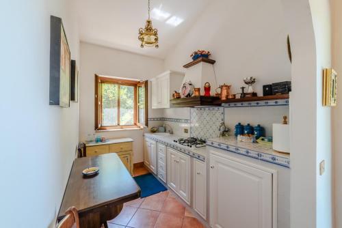 a kitchen with white cabinets and a table in it at Il Borgo nel bosco in Canterano