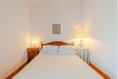 a bedroom with a bed with two lamps on it at Il Borgo nel bosco in Canterano