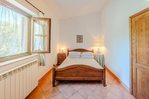 a bedroom with a bed and a window at Il Borgo nel bosco in Canterano