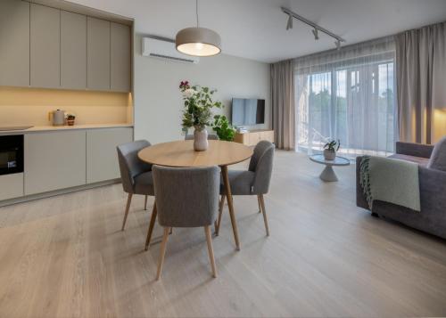 a kitchen and living room with a table and chairs at Apartamenty na Półwyspie Wydma&Las in Jastarnia