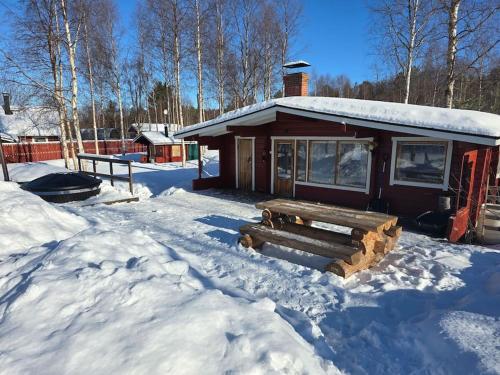 a log cabin in the snow with a bench at Experience amazing Ivalo 4,5km from the AirPort in Inari