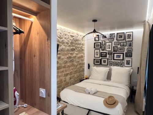 - une chambre avec un lit et un mur de photos dans l'établissement Studios Clouet-Paris Centre- XVe!, à Paris