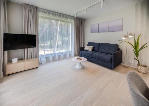 a living room with a couch and a tv at Apartamenty na Półwyspie Wydma&Las in Jastarnia