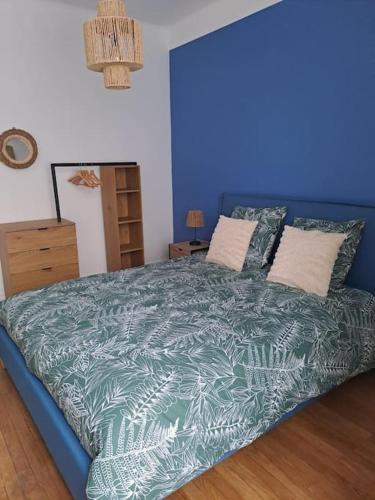 - un lit bleu dans une chambre dotée d'un mur bleu dans l'établissement Le Vaillant appartement Cosy, à Dijon