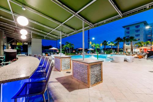 a patio with a swimming pool and blue chairs at TownePlace Suites by Marriott Orlando at SeaWorld in Orlando