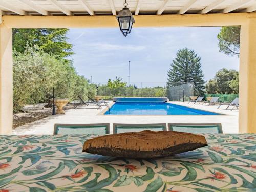 a bed with a pillow on top of it in front of a pool at Holiday Home Cucuron by Interhome in Cucuron