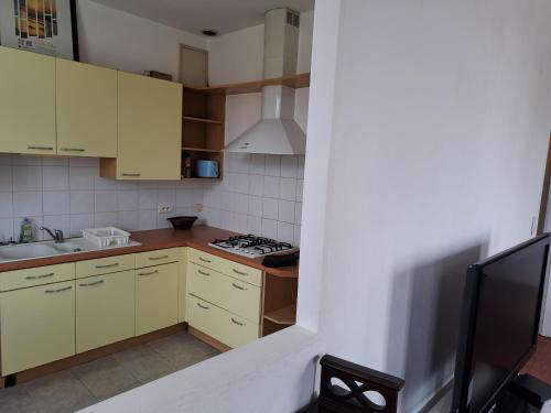 Elle comprend une petite cuisine avec des placards jaunes et un évier. dans l'établissement Duplex vue dégagée sur le vieux Saintes, à Saintes