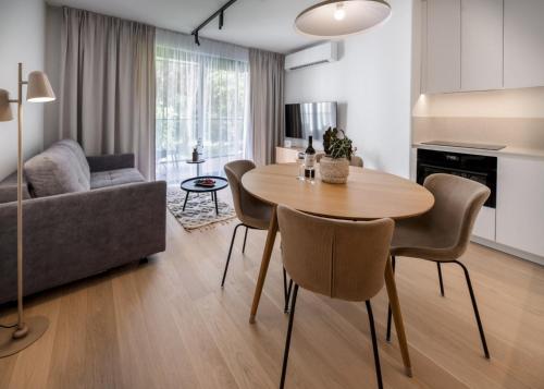 a living room with a table and chairs and a couch at Apartamenty na Półwyspie Wydma&Las in Jastarnia