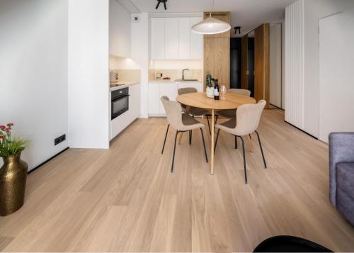 a kitchen and dining room with a wooden table and chairs at Apartamenty na Półwyspie Wydma&Las in Jastarnia