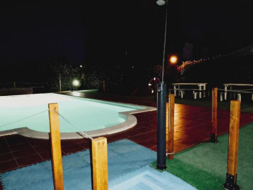 a swimming pool at night with a fence at Hotel Vitorio in Cudillero