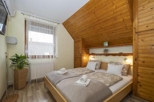 una camera da letto con un letto grande con soffitto in legno di Ács Apartman a Hévíz