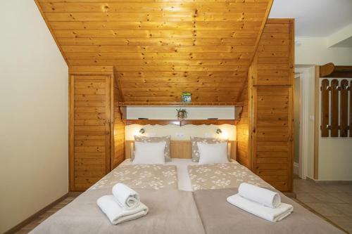 una camera da letto con un letto grande con due asciugamani bianchi di Ács Apartman a Hévíz
