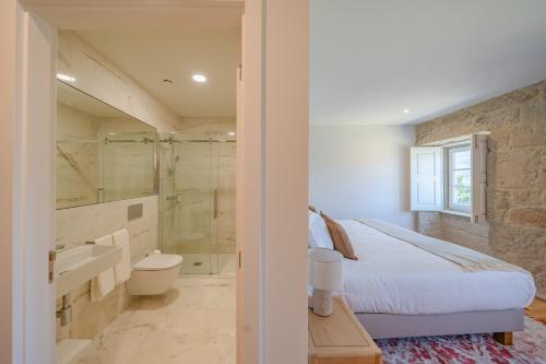 a bedroom with a bed and a bathroom with a tub at Feel Discovery Casa da Granja Douro Valley in Resende
