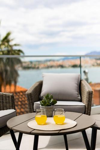 two glasses of orange juice on a table on a patio at Sea view APARTMENT PEPE in Podstrana
