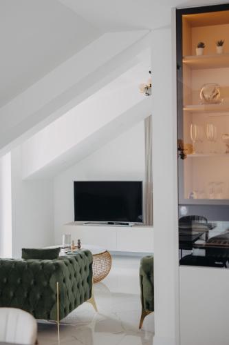 a living room with a green couch and a tv at Sea view APARTMENT PEPE in Podstrana