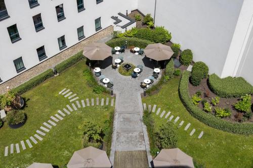 an overhead view of a courtyard with tables and umbrellas at Motel One Brussels in Brussels