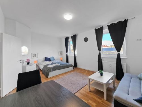 una sala de estar con una cama y una mesa en Stockerau Comfort Studio 1BR for 2, en Stockerau