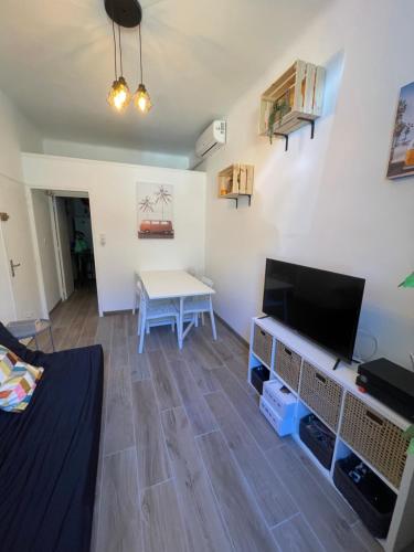 un salon avec une table et une télévision dans l'établissement Appartement 4 personnes à 2mn des plages, à Toulon
