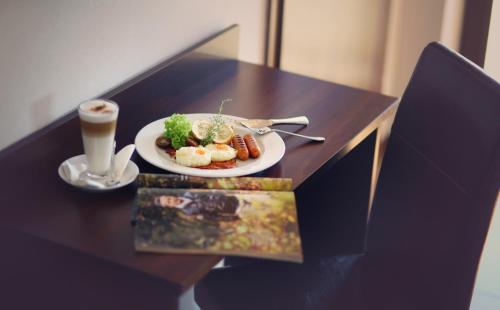 a table with a plate of food and a cup of coffee at Hippika in Połchowo