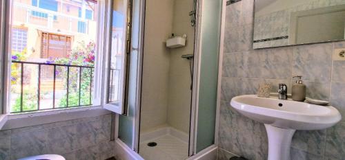 une salle de bain avec un lavabo et une douche dans l'établissement Charmant appartement, à Banyuls-sur-Mer
