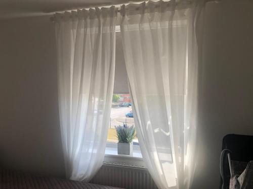 ein Fenster mit weißen Vorhängen im Schlafzimmer in der Unterkunft Basildon, private room in a flat in Basildon