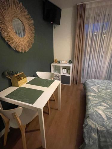 Cette chambre comprend une table blanche et un lit. dans l'établissement Joli studio piscine et parking 3km Honfleur, à Équemauville