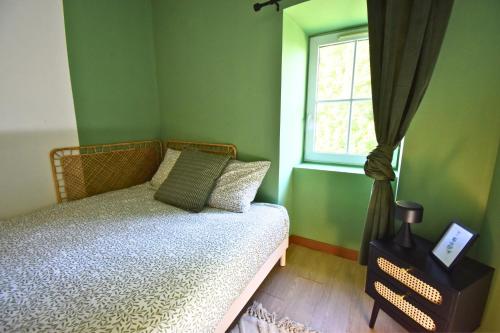 a green bedroom with a bed and a window at Évasion au Château Ravenel in Ravenel