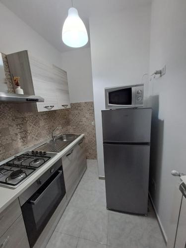 a kitchen with a stainless steel refrigerator and a microwave at Principe Umberto in Contursi Terme