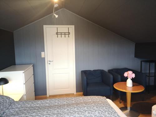 a bedroom with a bed and a chair and a table at Homestay Storesund in Storasund