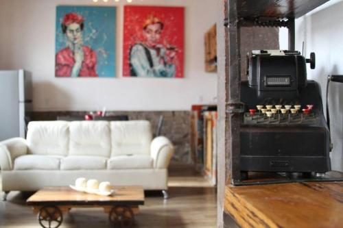 a living room with a white couch and a stove at Mexican Loft by LA Casa Cosme in the city center in San Luis Potosí
