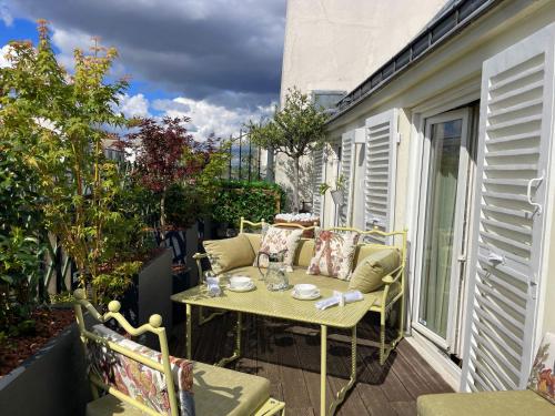 un patio avec une table et des chaises sur un balcon dans l'établissement Luxueux Appartement, avec terrasse vue Champs-Élysées, à Paris