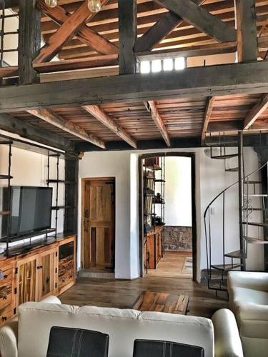 a living room with a couch and a tv at Mexican Loft by LA Casa Cosme in the city center in San Luis Potosí