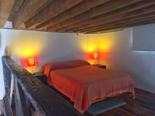 a bedroom with a bed with two lamps on it at Mexican Loft by LA Casa Cosme in the city center in San Luis Potosí