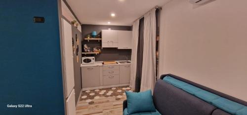 un soggiorno con un divano blu e una cucina di Blumon guest House a Napoli