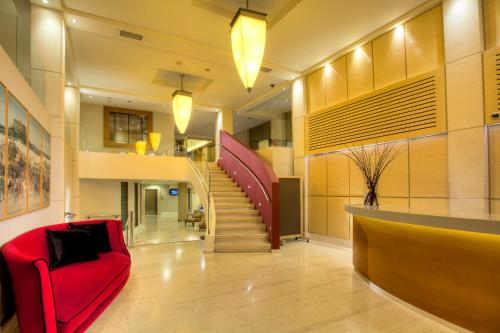 a living room with a red couch and a staircase at Central Hotel in Athens