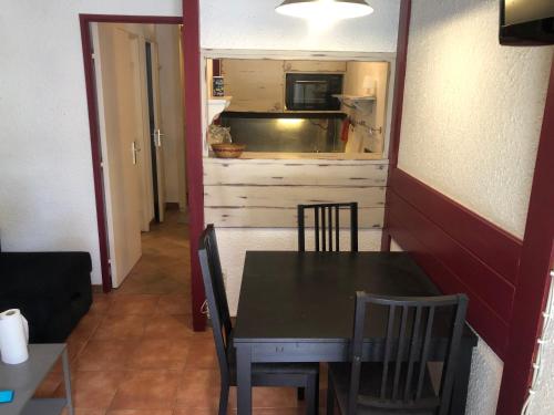 une salle à manger avec une table et des chaises et une cuisine dans l'établissement appartement avec une chambre, à Chamonix-Mont-Blanc