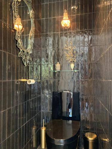 La salle de bains est pourvue d'un lavabo et d'un miroir sur un mur carrelé. dans l'établissement Villa Alba en Provence, à Besse-sur-Issole