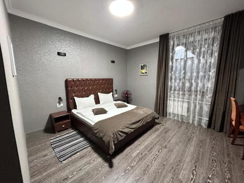 a bedroom with a bed and a large window at Deluxe SPA-Hotel in Ustʼ-Kamenogorsk
